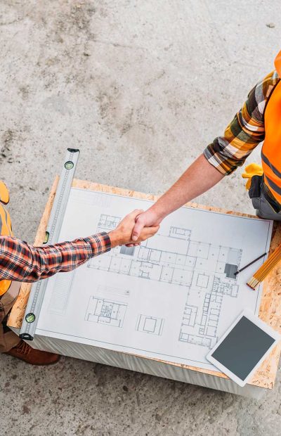 high-angle-view-of-builders-shaking-hands-over-blu-2022-12-16-19-16-13-utc.jpg